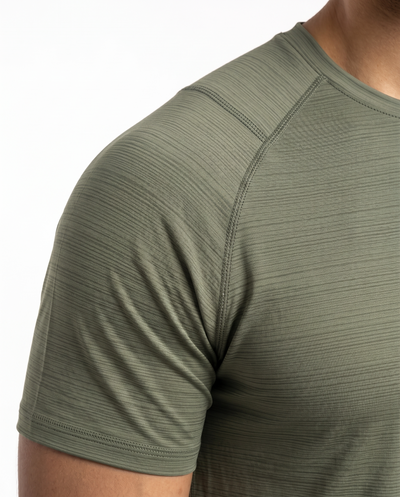 Man wearing an olive green athletic shirt on a white background
