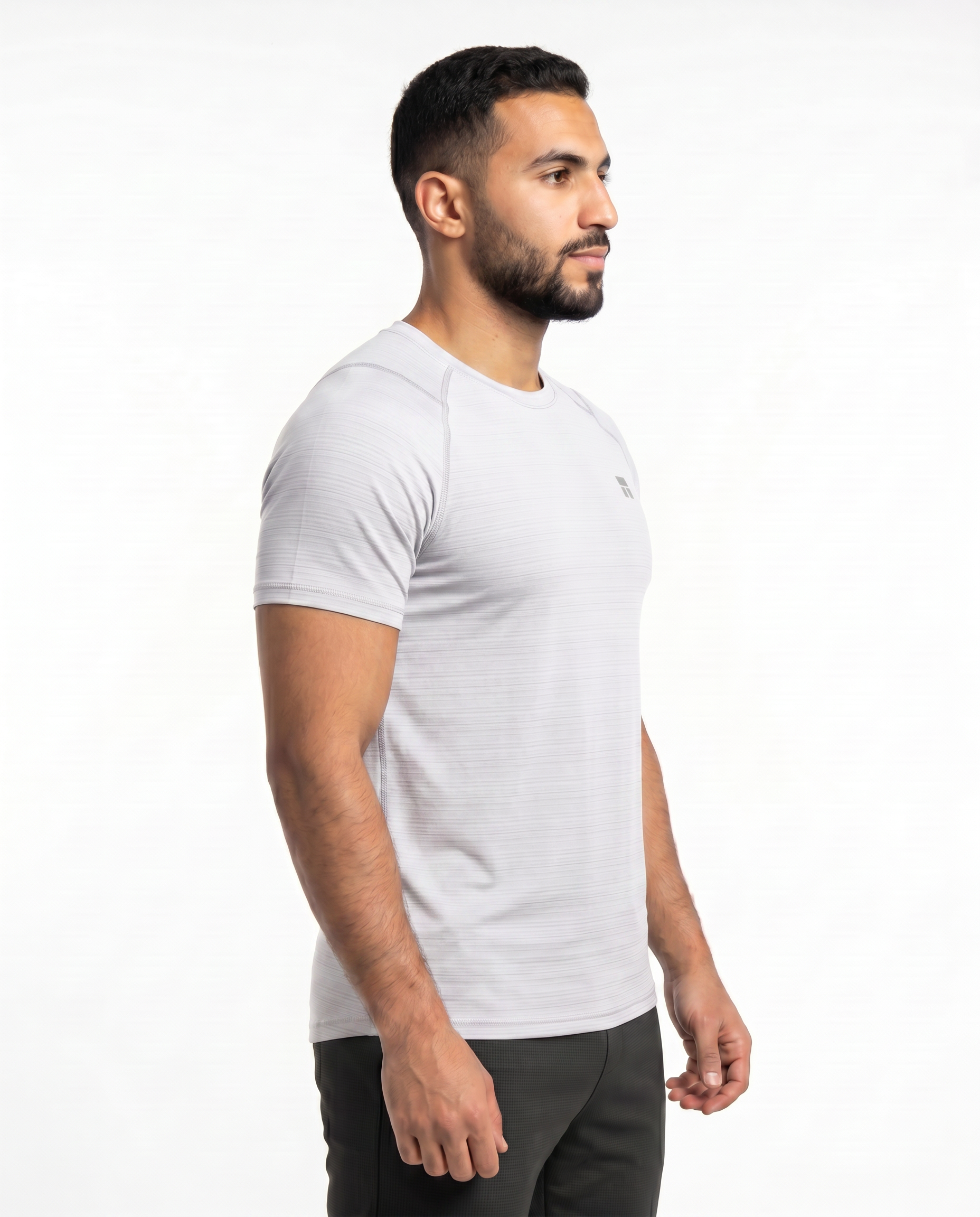 Man wearing a white t-shirt with a small logo on a white background
