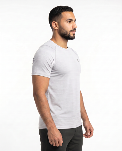 Man wearing a white t-shirt with a small logo on a white background

