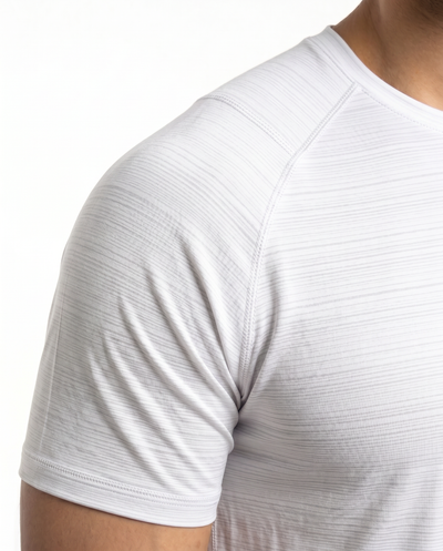 Man wearing a white t-shirt with a small logo on a white background
