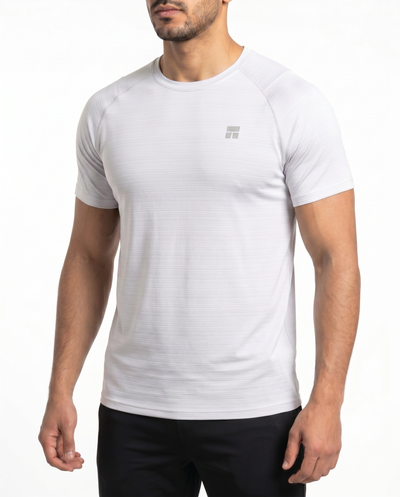 Man wearing a white t-shirt with a small logo on a white background
