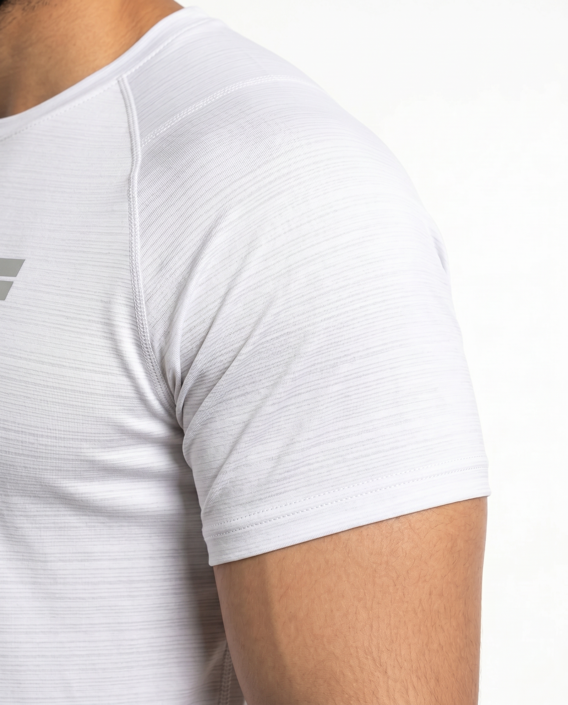 Man wearing a white t-shirt with a small logo on a white background
