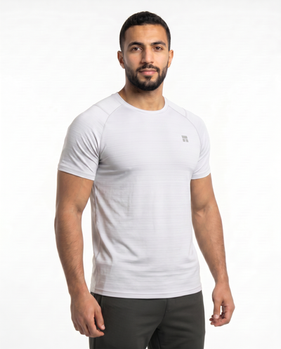 Man wearing a white t-shirt with a small logo on a white background
