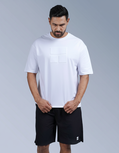 Man wearing a white t-shirt and black shorts on a gray background

