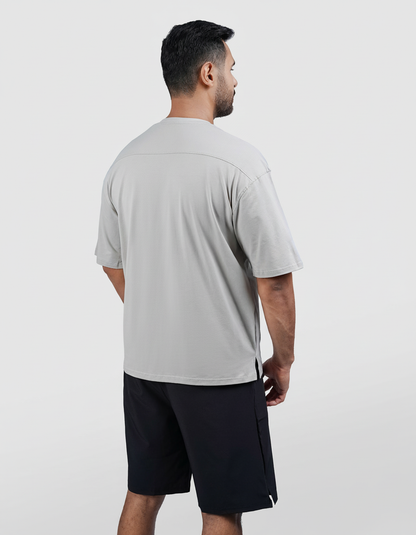 Man wearing a gray t-shirt and black shorts on a white background
