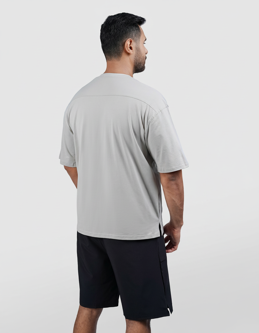 Man wearing a gray t-shirt and black shorts on a white background
