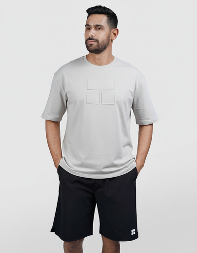Man wearing a gray t-shirt and black shorts on a white background
