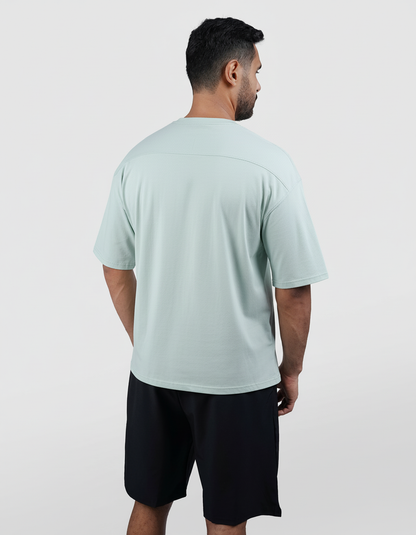 Man wearing a light blue t-shirt and black shorts on a white background

