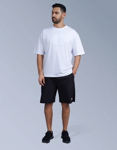 Man wearing a white t-shirt and black shorts on a gray background

