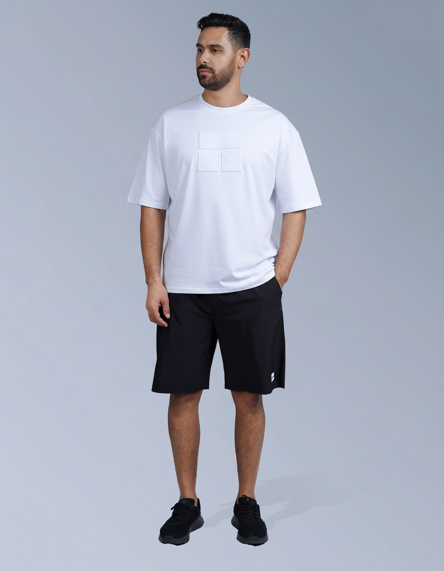 Man wearing a white t-shirt and black shorts on a gray background

