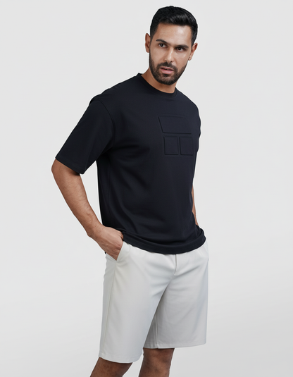 Man wearing a black t-shirt and white shorts on a light gray background

